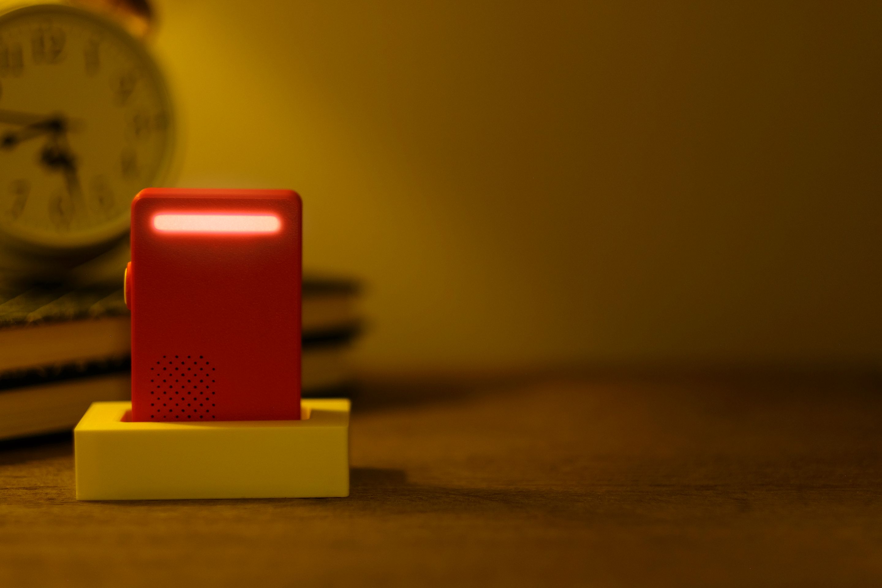 Poppy device on a nightstand with its light bar glowing